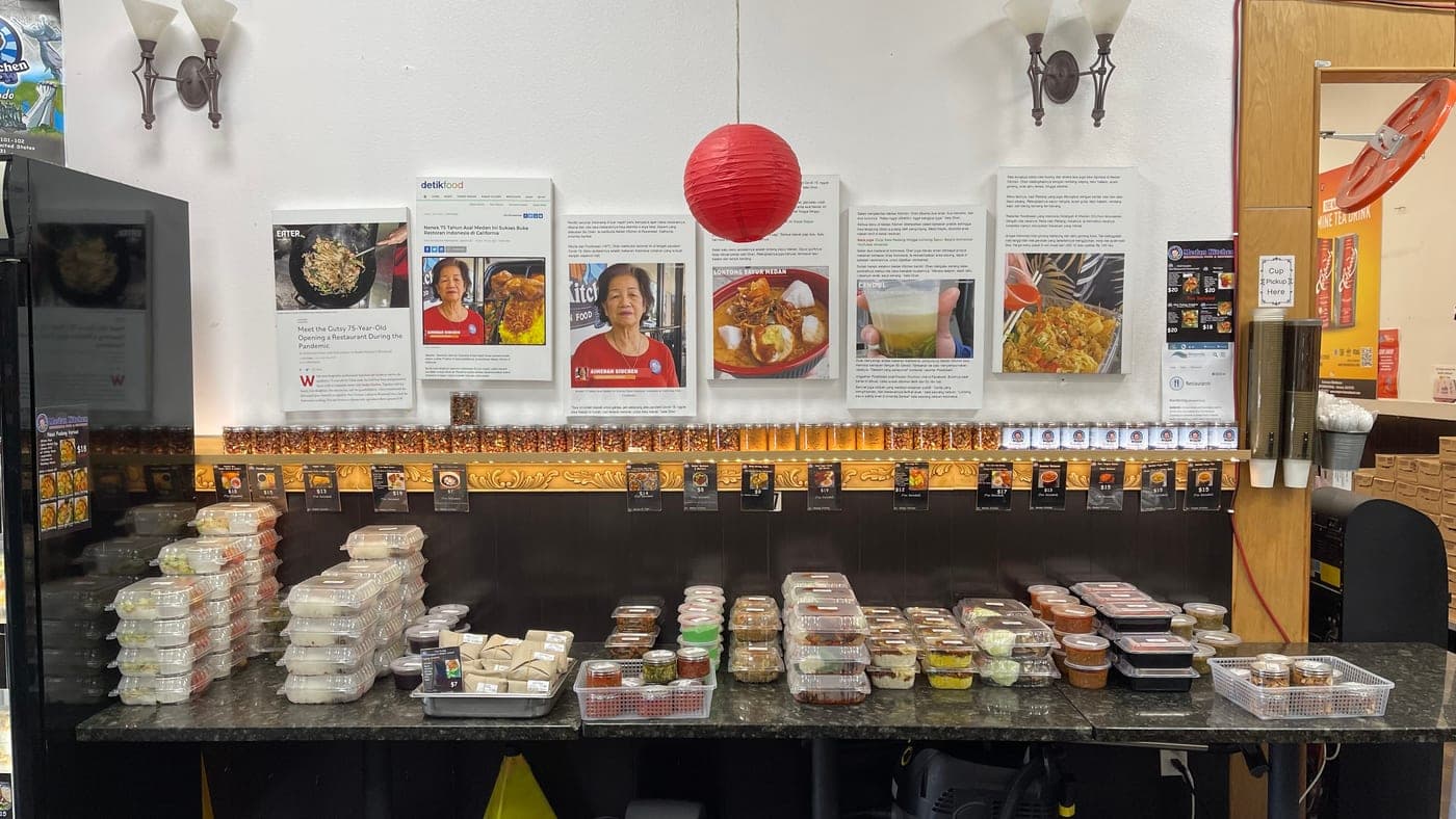 The right-hand counter, and above it the wall of framed articles written about the shop